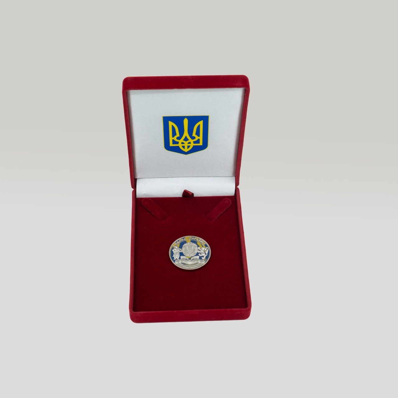Відкритий оксамитовий футляр з медаллю та тризубом на кришці